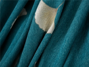 Macro shot of thick teal chenille sofa cover with golden ginkgo leaf weaving texture