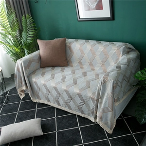 Close-up of thick chenille sofa cover with geometric V-pattern and elegant lace edges