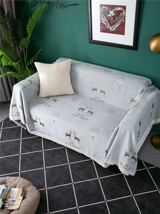 Detail of light grey chenille sofa cover with deer pattern and delicate white lace edges