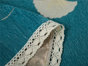Close-up of thick peacock blue chenille sofa cover with white lace ginkgo leaf edges