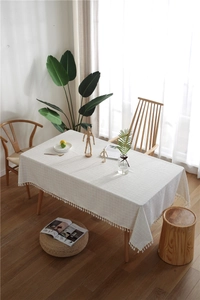 Close-up of cream rectangular tablecloth with checkered jacquard and cotton fringe