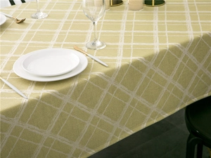 Close-up of olive green checkered tablecloth with textured cotton linen fabric and fringe