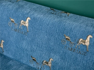Detail of thick blue chenille sofa cover with embossed carriage pattern and fabric texture