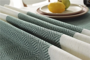 Macro detail of waterproof wavy geometric weave table runner with fringe and green tones