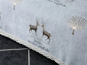 Close-up of light blue chenille sofa cover with deer patterns and white lace edges