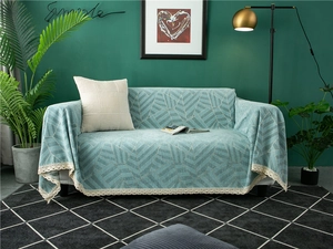 Detail of thickened chenille sofa cover with geometric leaf patterns and lace trim edges