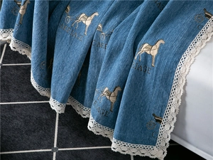 Detailed close-up of blue chenille sofa cover with carriage print and white lace trim