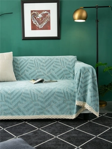Detail of light blue chenille sofa cover with grey geometric patterns and white lace edges