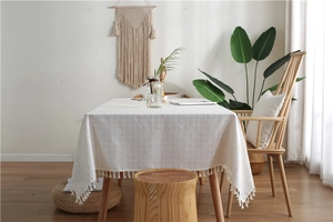 Close-up of geometric plaid tablecloth with fringe edges in a cozy home setting