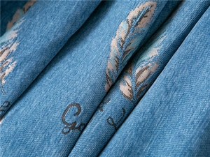 Macro view of blue chenille fabric with feather jacquard and Grace lettering details
