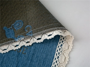 Close-up of thick chenille sofa cover showing vintage embroidery and delicate lace trim