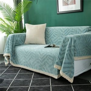 Close-up of chenille sofa cover featuring geometric leaf patterns and delicate white lace trim
