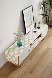 Detail of chenille table runner with geometric hexagon pattern and white tassel fringe