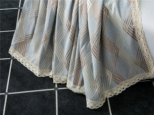 Close-up of geometric chenille sofa cover fabric with elegant white lace edge detail