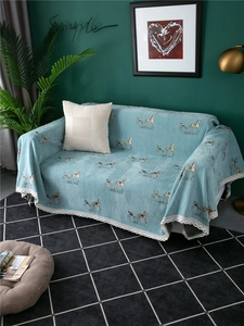 Detail of light blue chenille sofa cover with carriage print and white lace trim