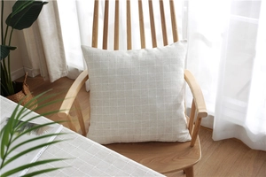 Close-up of cream textured jacquard fabric cushion cover on a wooden chair
