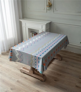 Detail shot of geometric patterned linen tablecloth with zigzag and wave prints on wood table