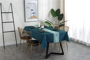 Detail of waterproof dark green geometric tablecloth with Nordic lettering on a dining table
