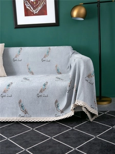 Close-up of thick chenille sofa cover with feather prints and delicate lace edging