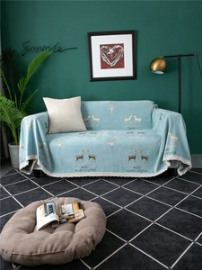 Detail of blue chenille sofa cover featuring elk pattern and delicate white lace trim