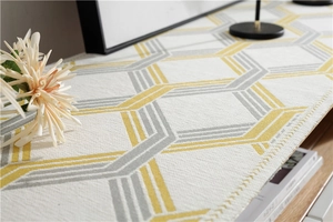 Detailed texture of chenille table runner with yellow and grey geometric hexagon patterns