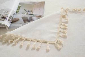 Detail of off-white thickened tablecloth featuring elegant fringe edges and cotton texture