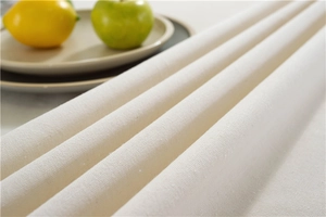 Close-up of thick beige tablecloth fabric texture with tassels and woven detail