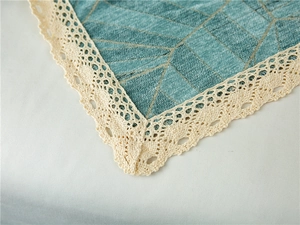 Detail of chenille sofa cover showing lake green fabric and white crochet lace edges