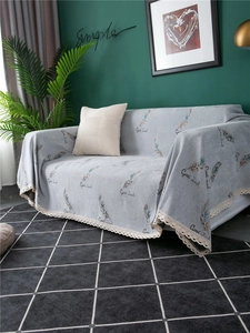 Close-up of light grey chenille sofa cover with feather print and white lace trim