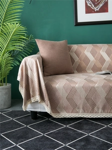 Detail of geometric chenille sofa cover with exquisite beige lace edges and leaf plants
