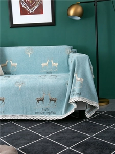 Close-up of chenille sofa cover with deer pattern and elegant white lace edging