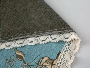 Detail of thick chenille sofa cover with vintage carriage print and white lace trim