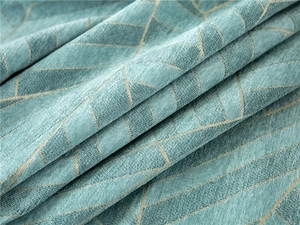 Close-up of thick chenille fabric with blue and beige geometric diamond pattern texture