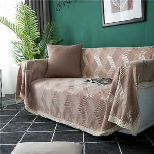 Detail of chenille sofa cover with geometric diamond patterns and white lace edges