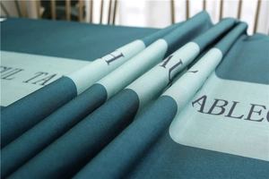 Close-up of dark green waterproof tablecloth with textured fabric and white lettering