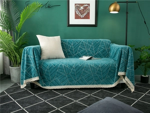 Close-up of thick chenille sofa cover with teal geometric patterns and lace edges