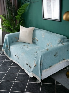 Detail of light blue chenille sofa cover with deer patterns and white lace edges