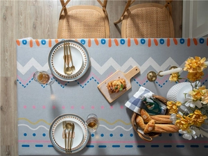 Detail of grey rectangular tablecloth with Nordic geometric prints and tassel edges