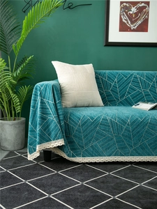 Close-up of blue chenille sofa cover featuring geometric patterns and white lace edges