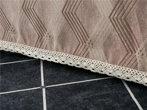 Macro detail of brown chenille sofa cover with geometric pattern and white lace edge