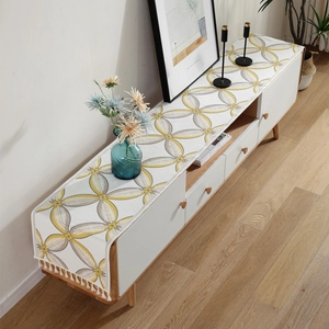Modern chenille table runner with yellow and grey leaf patterns and white tassels