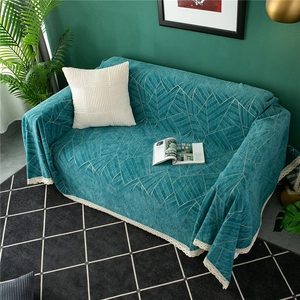 Detail of teal chenille sofa cover with geometric patterns and white lace edges