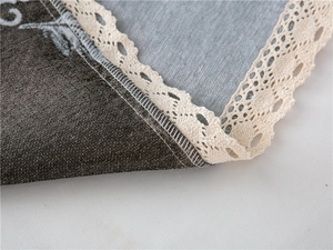 Detail of chenille sofa cover with dark coffee fabric and elegant cream lace edge trim
