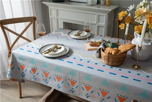 Detailed close-up of geometric printed tablecloth with vibrant tribal patterns on dining table
