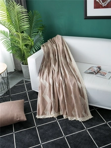 Detail of chenille sofa cover showing geometric pattern and delicate lace edges on furniture