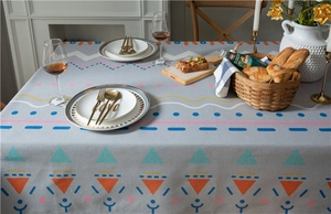 Detail of thick faux linen tablecloth with colorful geometric patterns and soft drape