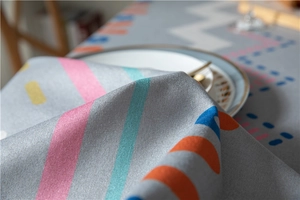 Close-up of thick textured table cloth with colorful geometric stripes and ripple patterns