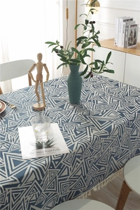 Detalle de mantel jacquard geométrico azul marino con borlas de flecos suaves