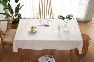 Close-up of yellow daisy pattern on cream rectangular cotton floral tablecloth