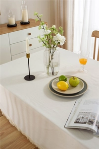 Close-up of white thick cotton linen tablecloth with decorative tassel edge details
